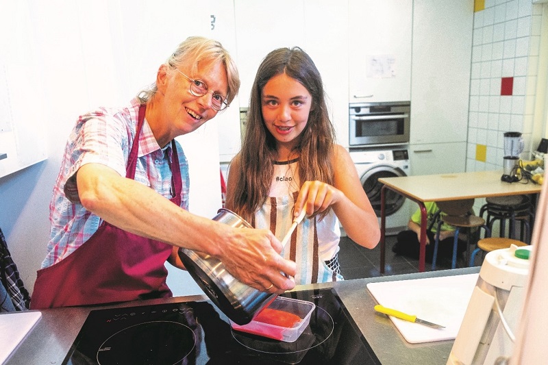 Anneke Cnossen is samen met een leerling aan het koken