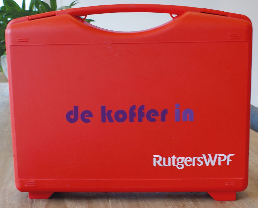 de rode koffer op een tafel, met tekst: de koffer in, RutgersWPF