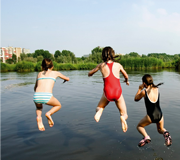 3 kinderen springen in het water