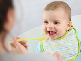 blije baby krijgt een hapje van een lepeltje