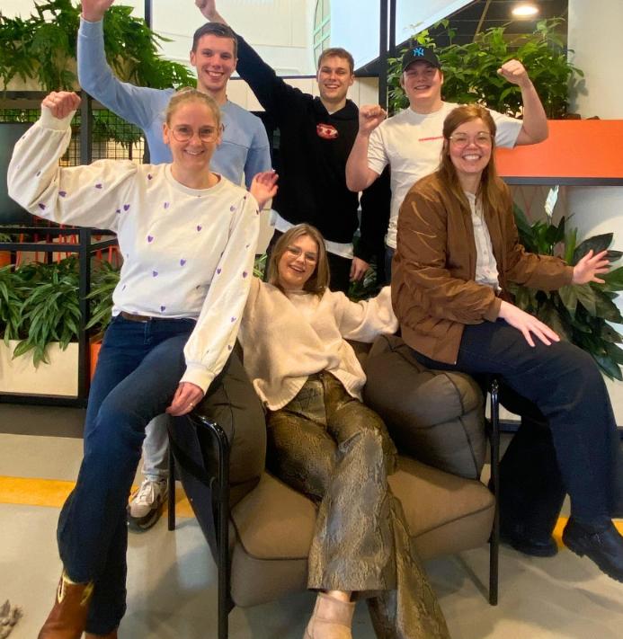 Foto van 6 personen die bij elkaar zitten en juichen. Op de foto staan studenten van het ontwerpteam van ROC van Twente en medewerkers van team Seksuele gezondheid van GGD Twente.
